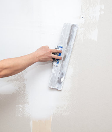 A man is plastering a wall in the house.の写真素材