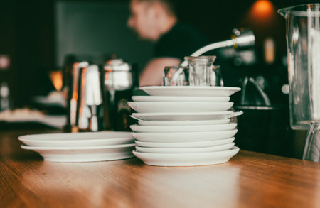Stack of white dishes on a wooden table in the kitchen. selective focus.の写真素材