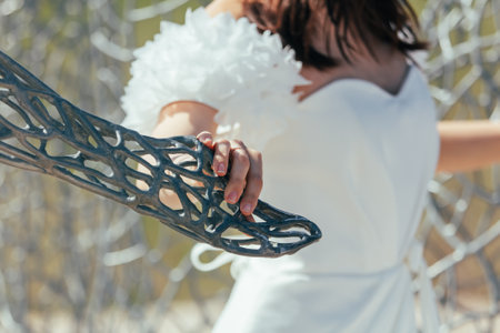 bride's hand on the background of the chain-link fence.