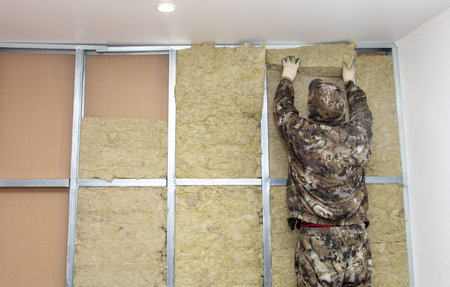 Workers insulate the wall in the room.