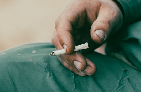 closeup of a man's hand holding a cigarette.の写真素材