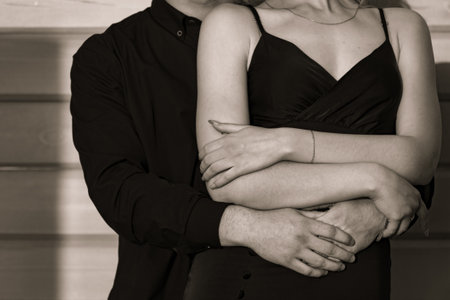 Man and woman in a black dress embracing each other. close-up.の写真素材