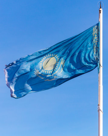 Flag of the Republic of Kazakhstan waving in the wind against the blue sky.の写真素材