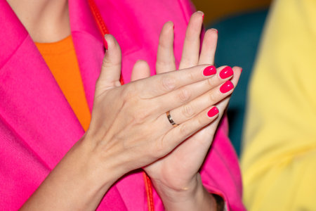 Close-up of a girl's hands with red manicure claps her hands.の写真素材