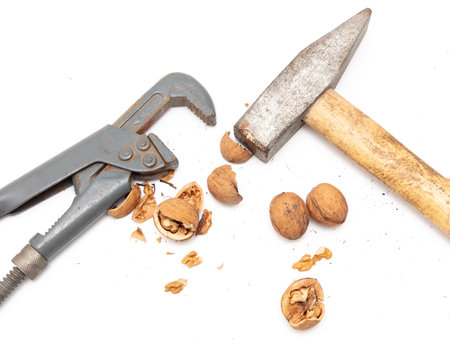 Hammer, nutcracker and walnuts isolated on white background.の写真素材
