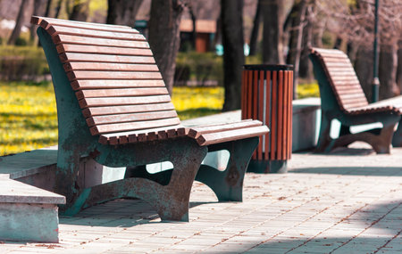 Wooden bench and trash can in the park. selective focus.