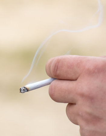 Close-up of a cigarette in a man's hand. Macroの写真素材
