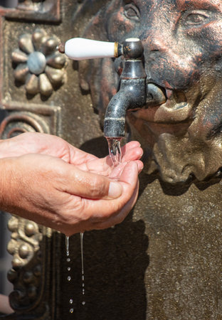 Men's hands washes with water in the washbasin.の写真素材