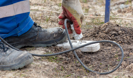 A worker plugs the plug into an extension socket at a construction site.の写真素材