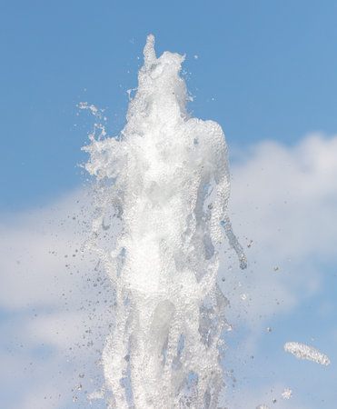 Fountain splashes against the blue sky. background.の写真素材