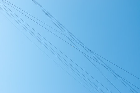 Electric wires against the blue sky.