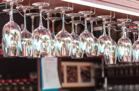 Clean glasses hang over the bar.の写真素材