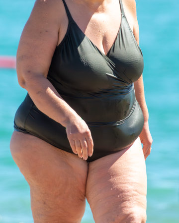 Fat woman on the beach near the sea.の写真素材