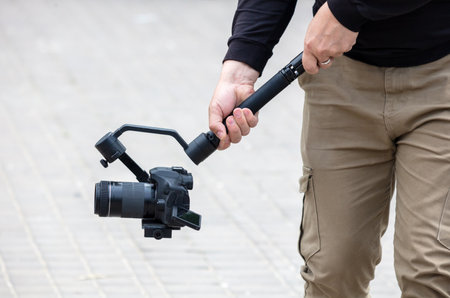 The operator shoots a video holding a professional video camera in his hands.の写真素材