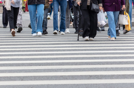 People cross the road on a white zebra on an asphalt road.の写真素材