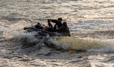 A water scooter rides with splashes of water on a river.の写真素材