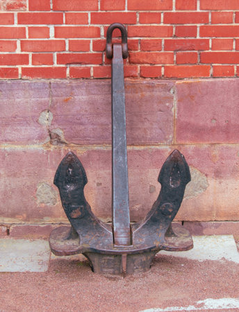 A large metal anchor against the wall of a brick house.の写真素材