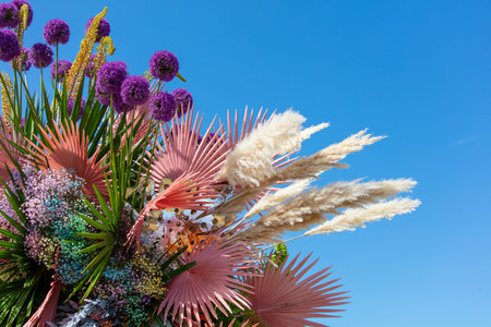 A bouquet of purple flowers against a blue sky.の写真素材