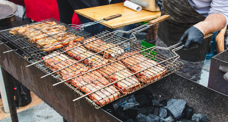 The meat is fried on the grill over the coals of the grill.の写真素材