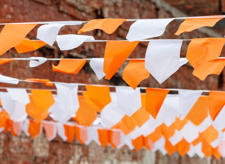 Festive white-orange flags as a background.