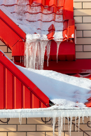 Icicles hang from the roof of the house. Winter.の写真素材