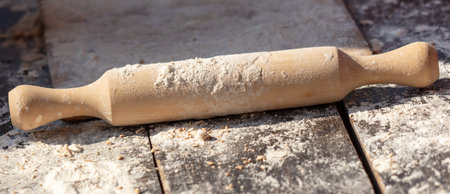 Rolling pin with flour on a wooden table.