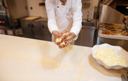 The cook rolls out the dough in the kitchen.