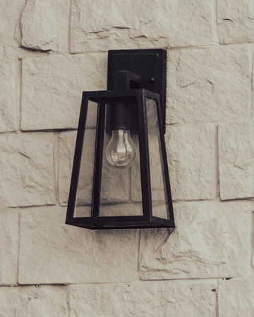 The lamp hangs on the brick wall of the house.の写真素材