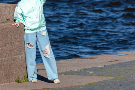 A girl in torn jeans by the river.の写真素材