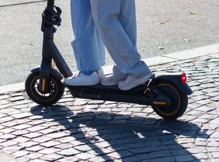 Two people ride a scooter in the city.の写真素材