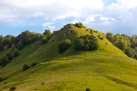 Green mountains in summer against the background of the sky with clouds.