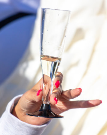 A glass of champagne in the hands of a girl.の写真素材