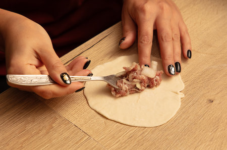 The girl makes manti on the table.の写真素材