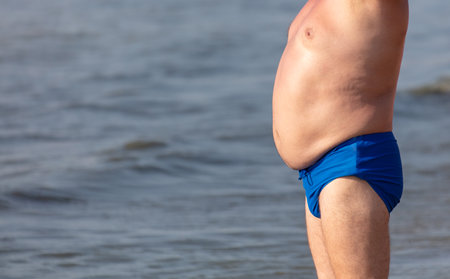 A man in swimming trunks against the background of the sea.の写真素材