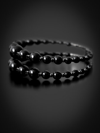 Black bracelet isolated on black background.の写真素材