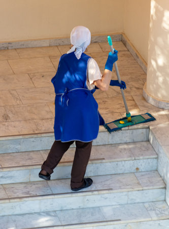 A woman washes the floor on the stairs in a building.の写真素材
