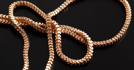 Gold chain isolated on black background. Close-up.