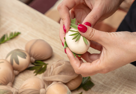A girl cooks eggs in tights with leaves. Easter.の写真素材