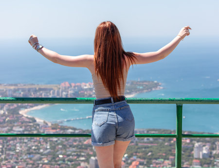 A girl in shorts looks at the sea. Back view.の写真素材