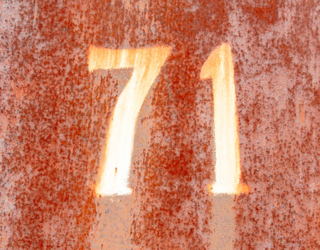 The number 71 on a rusty metal fence.の写真素材
