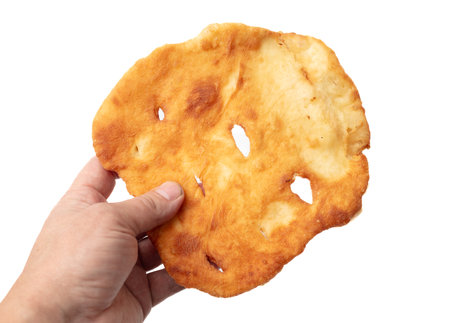 Fried flatbread in hand isolated on white background.