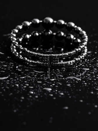 Women's bracelet in drops of water on a black background.