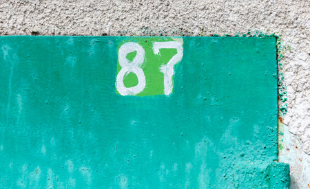 The number 87 on a rusty metal fence.の写真素材