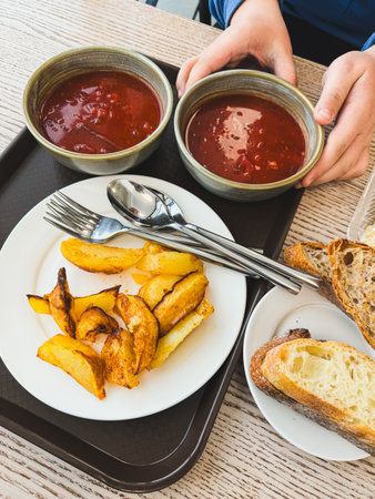 Fried potatoes borscht and bread on the table.