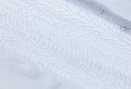 Traces from car wheels in the snow in winter as a background.の写真素材