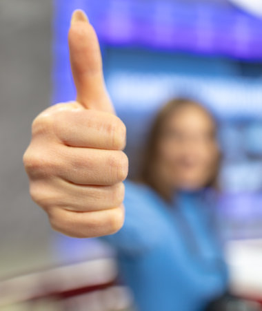 Girl shows thumbs up close up.の写真素材