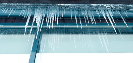 Icicles hang from a glass building.の写真素材
