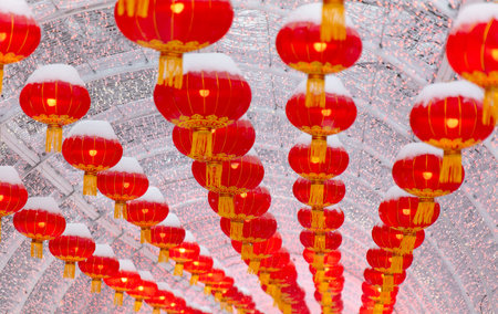 Red lanterns in the snow in the park. Chinese New Year holiday.