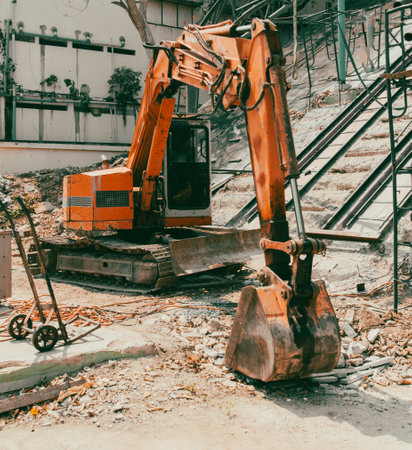 A red excavator works at a construction site.