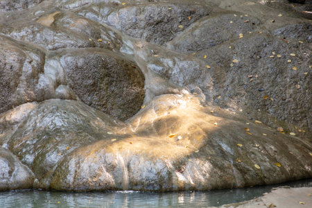 Water flows down a stone wall in nature.の写真素材